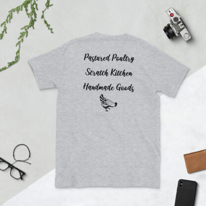 A gray t-shirt displaying 'Pastured Poultry, Scratch Kitchen, Handmade Goods' in black script lettering.