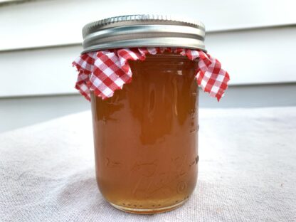 An 8 ounce jar of home-canned apple cider jelly.